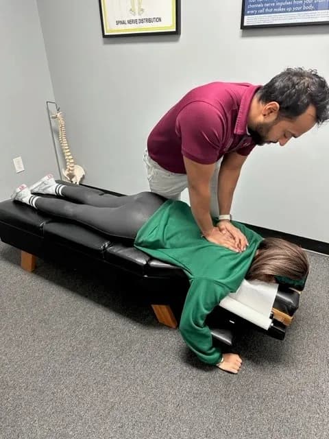 Chiropractor performing a mid-back adjustment on a patient at Breakaway Chiropractic in Frisco, TX